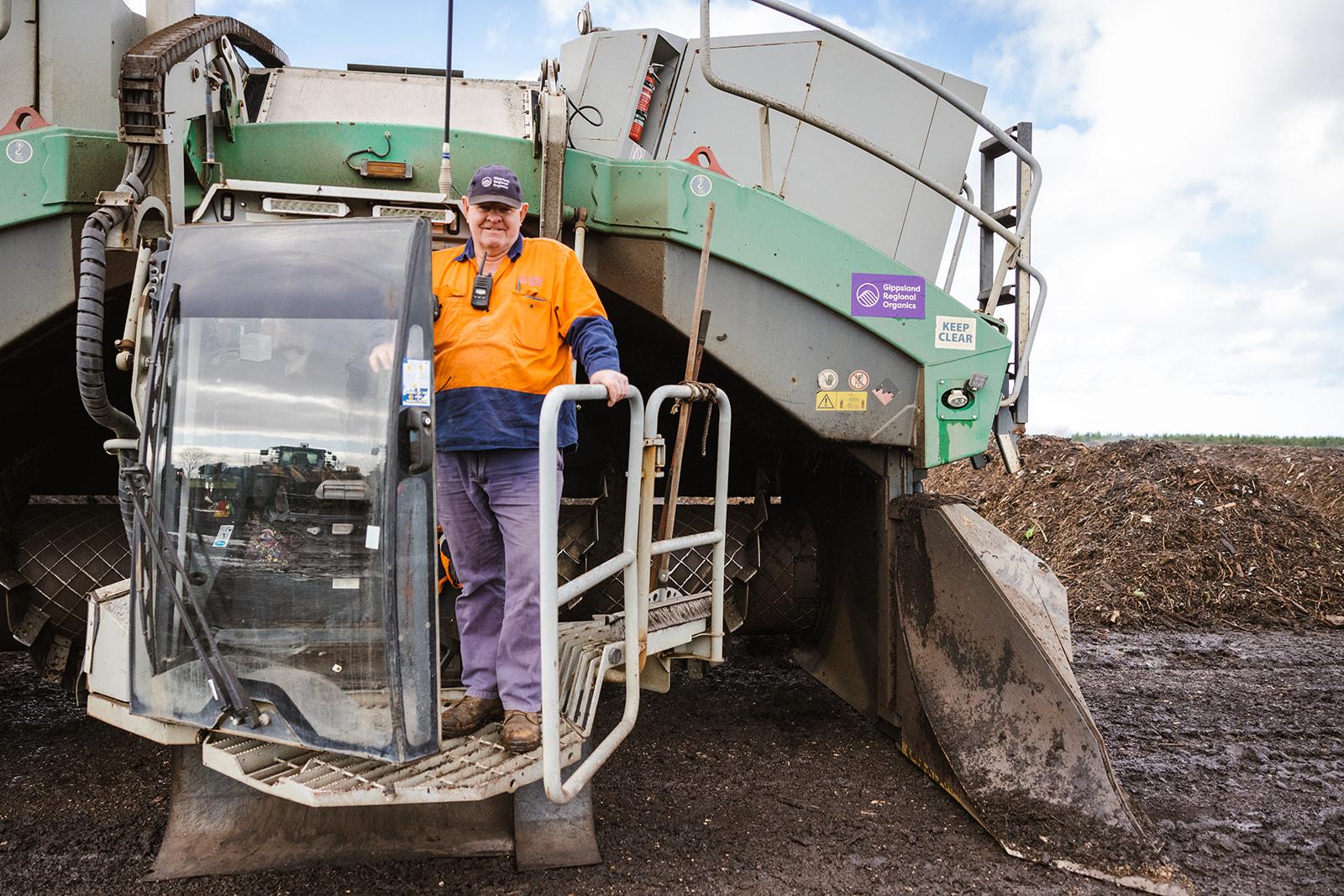 A worker for Gippsland Regional Organics, on a waste processing machine