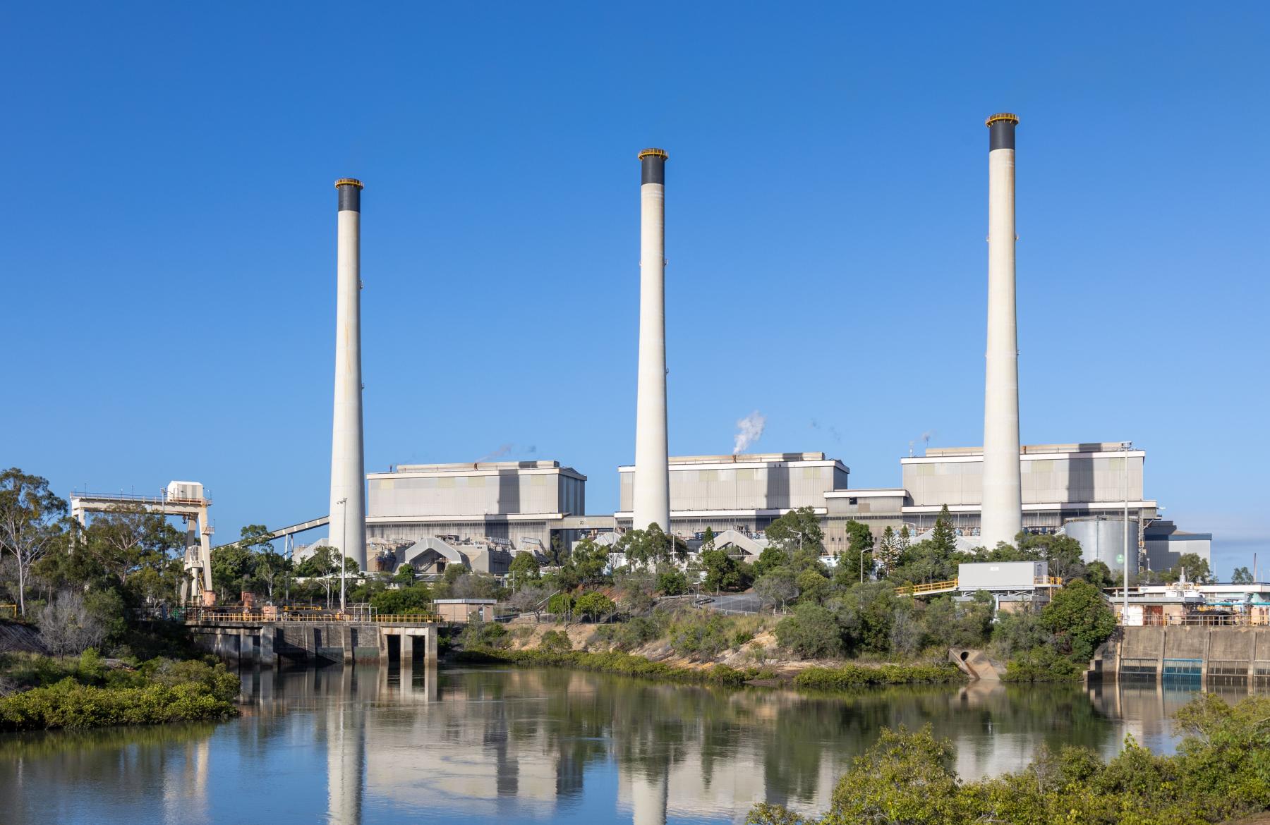 Three buildings with chimneys overlooking a lake