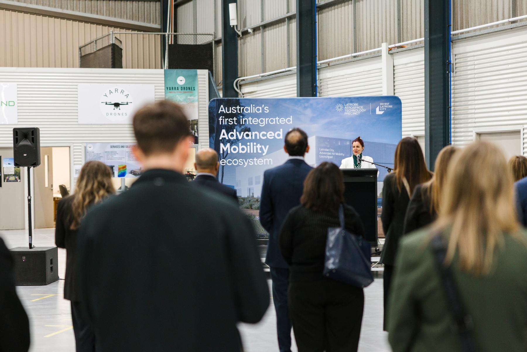 Sharron Gibson presents to an audience in front of a banner for the Latrobe Aerospace Technology Precinct