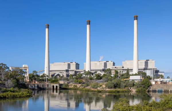 Three buildings with chimneys overlooking a lake