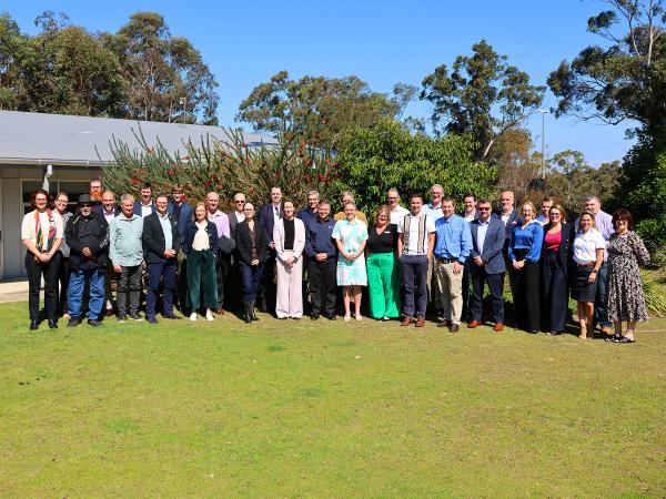 A collection of people standing on a lawn facing the camera