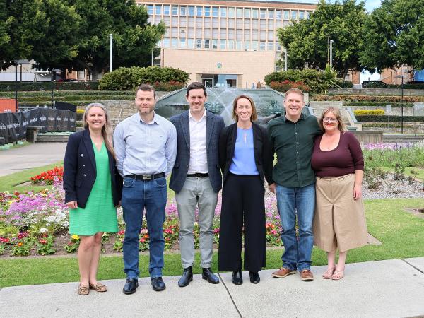 6 people standing in front of a fountain located in the Hunter